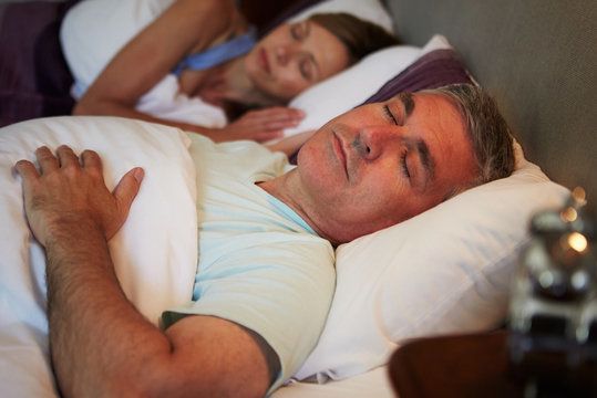 A man sleeping next to his wife